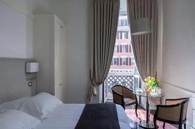 a hotel room with a bed and a table with chairs at Hotel Scalinata Di Spagna in Rome