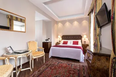a bedroom with a bed and a table and a tv at Hotel Nazionale in Rome