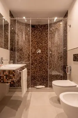 a bathroom with a shower and a toilet and a sink at Hotel Nazionale in Rome