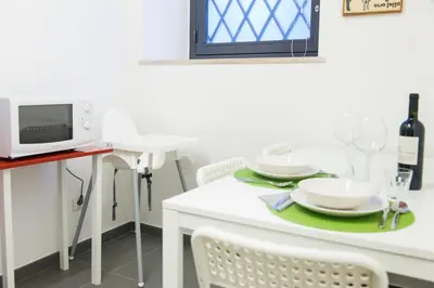 a white table with plates and wine glasses on it at Casa Brunetti in Rome