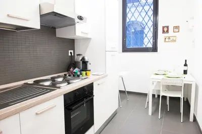 a kitchen with white cabinets and a stove top oven at Casa Brunetti in Rome
