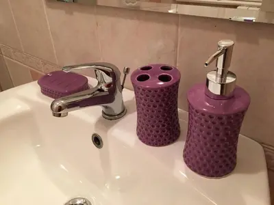 a bathroom sink with two purple containers on it at Dormi a Roma in Rome