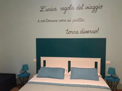 a bedroom with a bed with a green headboard at Dormi a Roma in Rome
