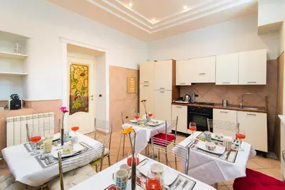 a living room with two tables and a kitchen at B&B Arco Di Gallieno in Rome