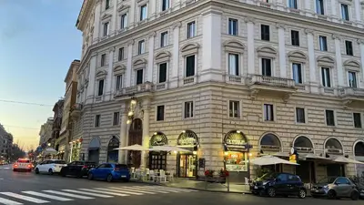 a large building on a city street with cars parked in front at Glam Sm Maggiore Guest House in Rome