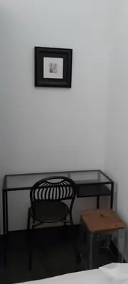 a desk with a chair and a picture on the wall at Retro Rooms Termini in Rome