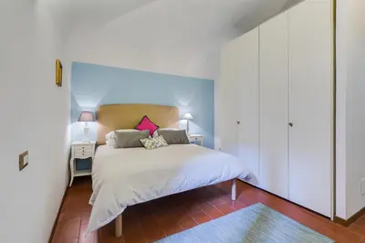 a bedroom with a bed with white sheets and pink pillows at Purificazione 44 Guest House in Rome