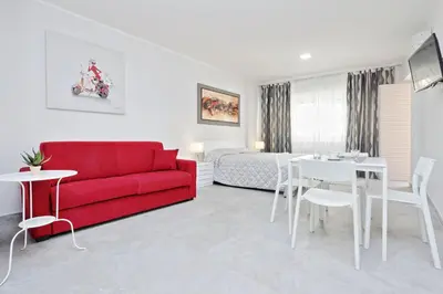 a living room with a red couch and a table at Valery Guest House in Rome