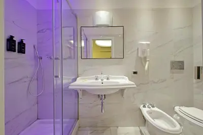 a white bathroom with a sink and a shower at Alla Locanda Malandra in Rome