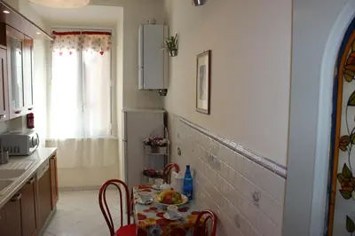 a small kitchen with a table and a refrigerator at Casa Vacanze Voglia di Roma in Rome