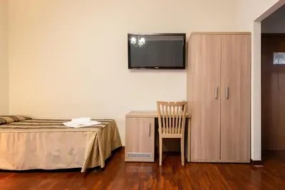 a bedroom with a bed and a cabinet and a chair at Dreams Roma B&B in Rome