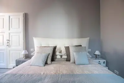 a bedroom with a large bed with blue pillows at Trevi Luxury Maison in Rome