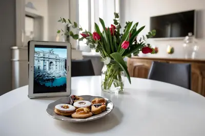 a tablet sitting on a table with a plate of donuts at Trevi Luxury Maison in Rome