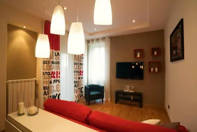 a living room with a red couch and a television at La Casa di Emma a Trastevere in Rome