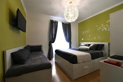 a bedroom with a bed and a couch and a chandelier at Jubilee 2 in Rome