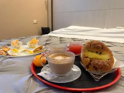 a tray with a breakfast of coffee and a pastry on a bed at Candia41 in Rome