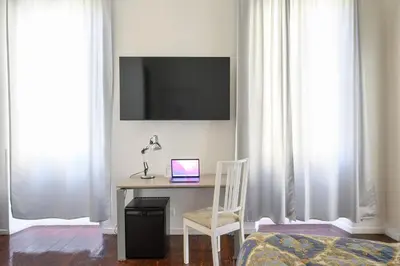 a desk with a laptop and a chair in a room at Relais Incantesimo Vaticano in Rome