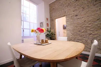 a dining room with a wooden table and a brick wall at Spanish Steps Art Apartment in Rome