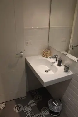 a white bathroom with a sink and a mirror at Spazio Cavour Guesthouse in Rome