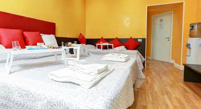 two beds in a room with red pillows at Termini Suites in Rome