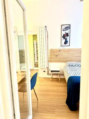 a bedroom with a bed and a table and a mirror at Angelico 90 in Rome