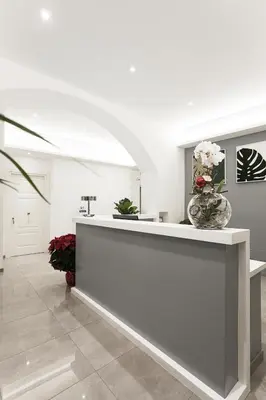 a lobby with a reception counter with flowers in a vase at Vaticano Luxury Guest House in Rome