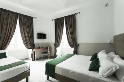 a hotel room with two beds and a desk at Vaticano Luxury Guest House in Rome