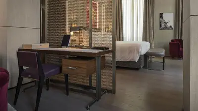 a hotel room with a desk with a laptop on it at Fendi Private Suites - Small Luxury Hotels of the World in Rome