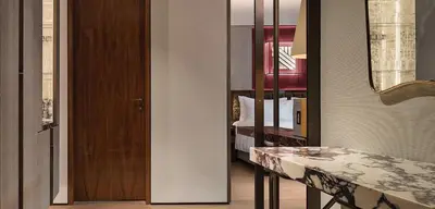 a room with a bedroom with a bed and a mirror at Fendi Private Suites - Small Luxury Hotels of the World in Rome