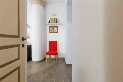 a red chair in a hallway with white walls at Cuore di Testaccio Apartment in Rome
