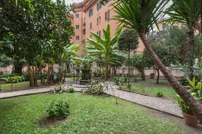 a park with palm trees and a building at Vatican White Domus in Rome