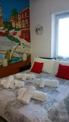 a large bed with white pillows on top of it at The Pope At The Window in Rome