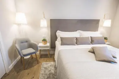 a bedroom with a large bed and a chair at Colonna Luxury Suites in Rome