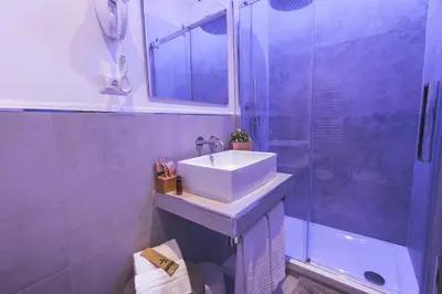 a bathroom with a sink and a shower at Colonna Luxury Suites in Rome