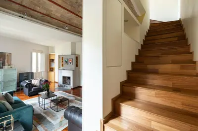 a living room with a staircase with wood floors at Trevi Charming Penthouse in Rome