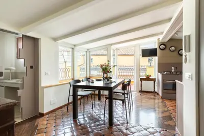 a kitchen and dining room with a table and chairs at Trevi Charming Penthouse in Rome