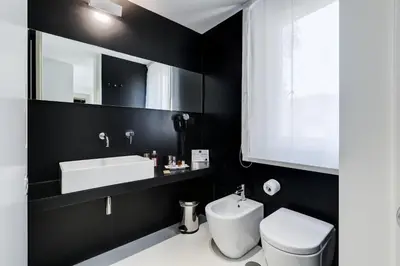 a bathroom with a white toilet and a sink at Sora Luxury Inn in Rome