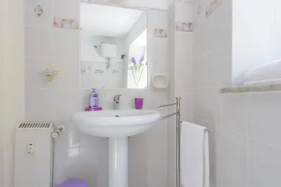 a white bathroom with a sink and a shower at Appartamento Castel Sant'Angelo in Rome