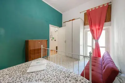 a bedroom with a bed and a red curtain at Sarah's House - Tourist Accommodation in Rome