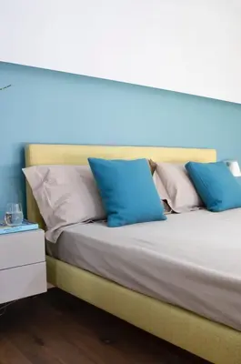 a bed with blue and white pillows on it at Le Quattro Dame Luxury Suites in Rome