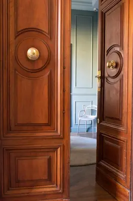 an open wooden door in a room with a chair at Le Quattro Dame Luxury Suites in Rome