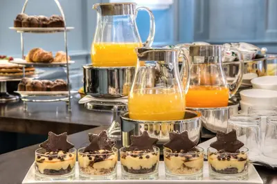 a buffet with desserts and pitchers of orange juice at Hotel Martis Palace in Rome