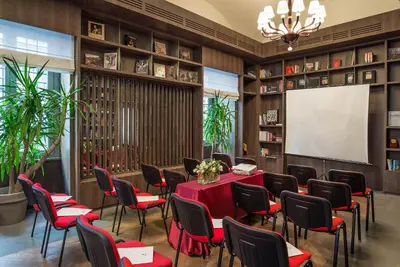 a conference room with a red table and chairs and a screen at Hotel Martis Palace in Rome