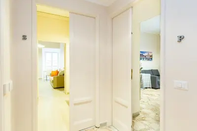 a hallway with a mirror and a living room at G-House Pettinari in Rome