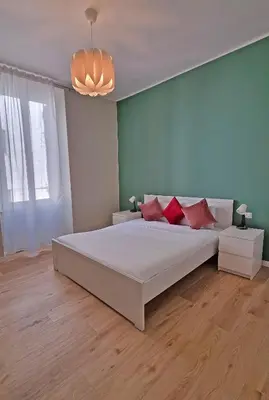a bedroom with a large white bed with red pillows at L'Esquilina Holiday House 2 in Rome