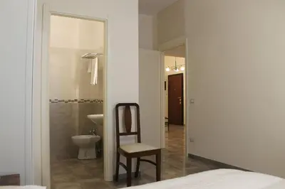 a bathroom with a toilet and a chair in a room at Anice Guesthouse in Rome