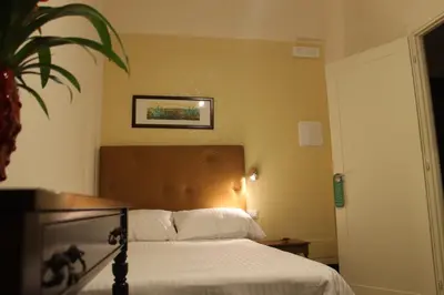 a bedroom with a bed and a potted plant at Anice Guesthouse in Rome