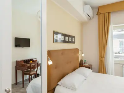 a bedroom with a bed and a table with a chair at Anice Guesthouse in Rome