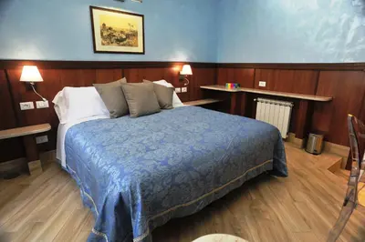 a bedroom with a bed with a blue blanket at Residenza Matteucci in Rome