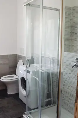 a bathroom with a washing machine and a toilet at Casa Santarelli in Rome